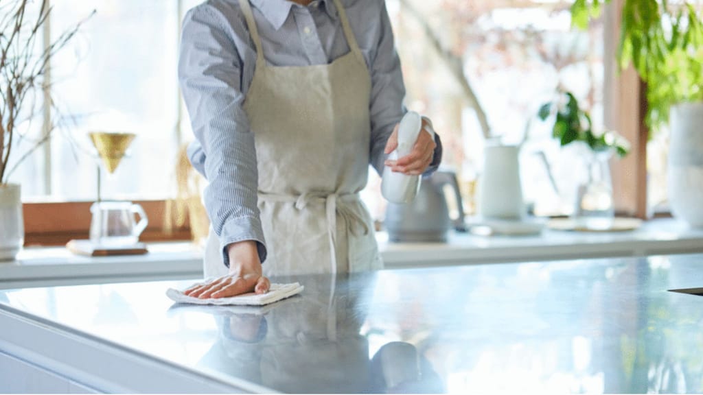 wiping kitchen countertops during deep cleaning a house before selling