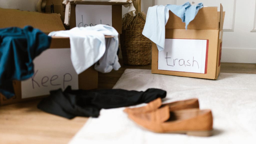 sorting items into keep and trash boxes while decluttering a home before selling
