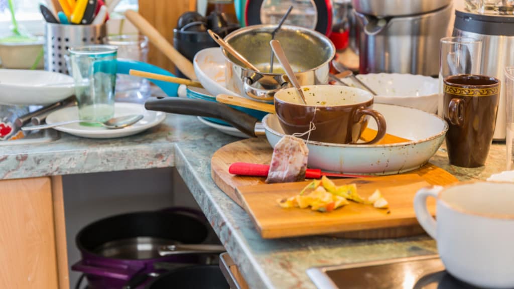 messy kitchen with dirty dishes showing what buyers do not want to see
