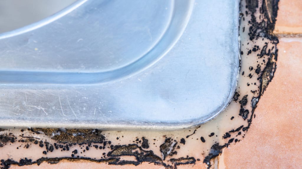 close up of moldy silicone or caulk around sink edge