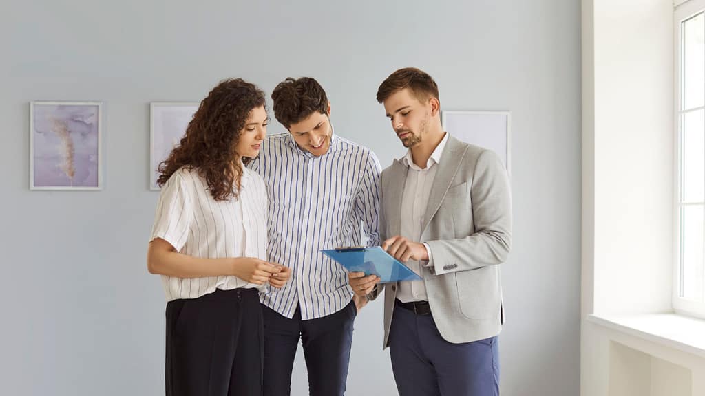 Couple reviewing documents with a real estate agent when learning how to choose a listing agent