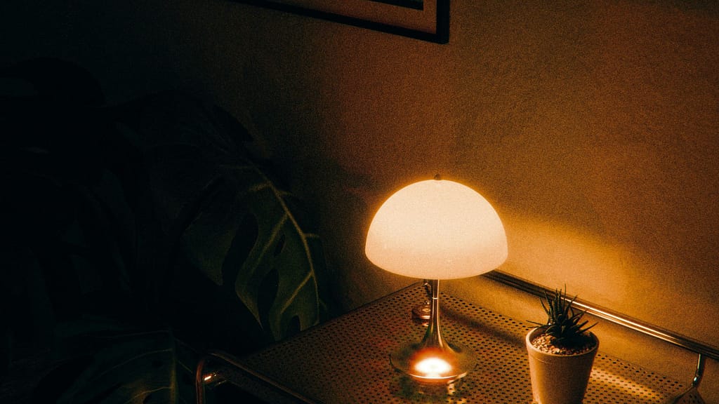 Warm table lamp providing layered lighting in a dimly lit room