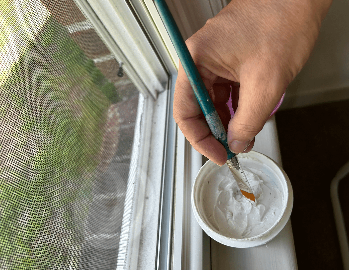 Applying wall filler with a brush during wall preparation before painting